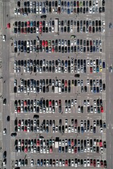 A vertical top-down panorama view of an expansive parking area, filled to capacity with vehicles.