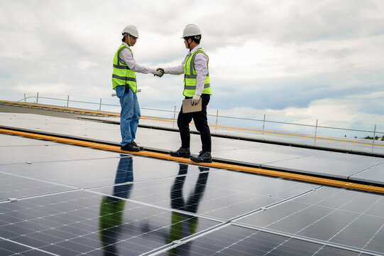 Two energy engineers greet each shake-hand in the workplace outdoors. Pleased to working together as a team.
