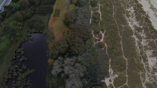 Aerial view of the border between lakes, sandy beaches and vegetation at Blankenberge, Flanders region, Belgium. Evening light