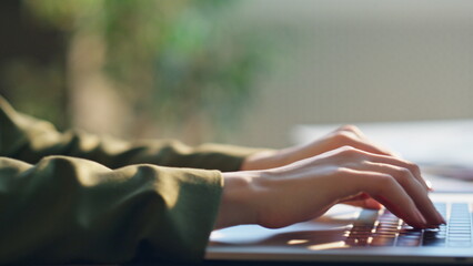 Girl freelancer typing laptop keyboard indoors. Woman writing text on notebook.