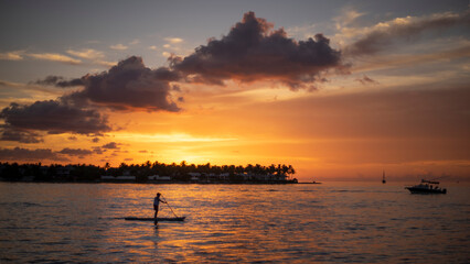 man on a paddle at sunset