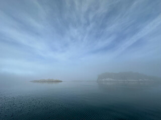 Scenic view of islands in fog near Stryker Island, British Columbia. Islands and blue, cloudy skies...
