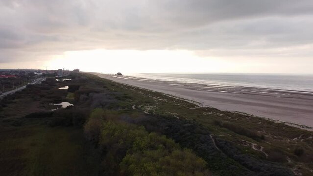 Aerial view of sunset, sandy beaches and endless ocean near Blankenberge, region of Flanders, Belgium. Evening light