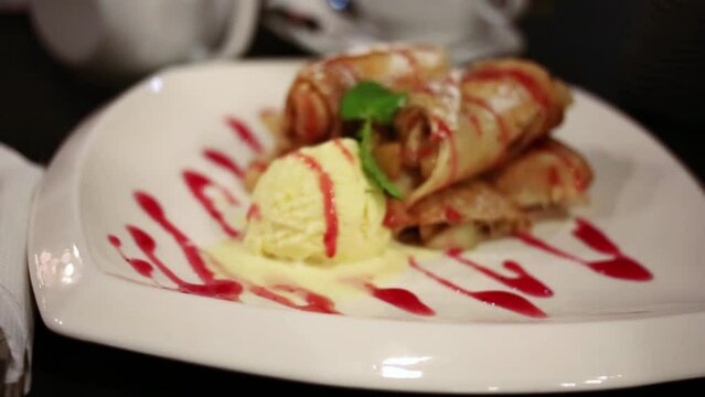 Pancakes with apple, ice-cream and jam on plate, close up view.