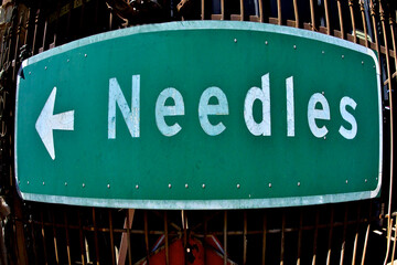 Distorted Needles, California Highway sign with direction arrow pointing left