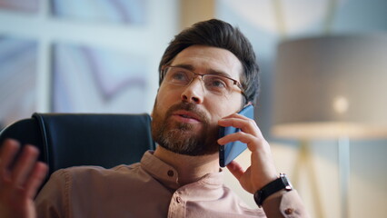 Relaxed businessman communicating smartphone sitting modern office close up.