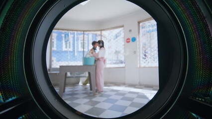 People using laundromat room in city. Closeup young hispanic man loading clothes