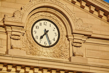 Golden Hour Clock on Historic Courthouse Facade, Low Angle View