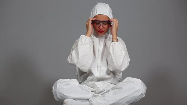 Beautiful girl undress protection mask and glasses sitting on floor