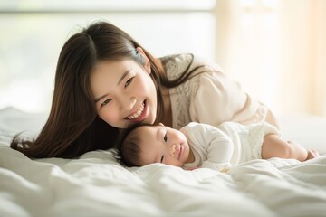 Obraz na płótnie Canvas Delighted Asian Mother Bonding With Newborn Baby On Bed, Brimming With Joy. Сoncept Couples Sunset Portraits, Adventure Travel Photography, Serene Landscapes, Pet Portraits