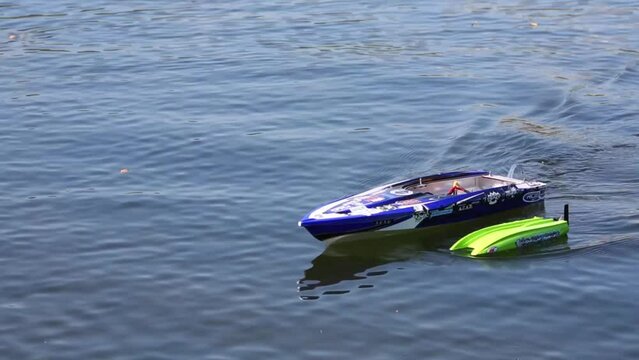 A toy boat in the water pushes the other boat which capsized