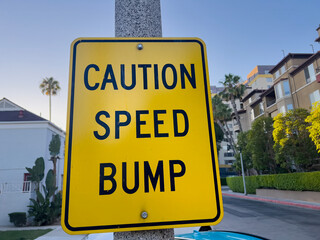 Caution speed bump sign on a street - 718276111