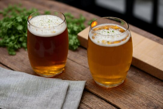 Glass of beer with steamed rice and parsley on wooden board