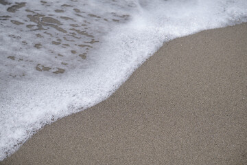 Top-down aerial view of a clean white sandy beach on the shores of a beautiful sea.