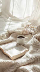 Aesthetic flat lay of a cozy morning. Soft blankets and a book, warm cup of coffee.  Neutral color backgroung for good morning Instagram stories or reels