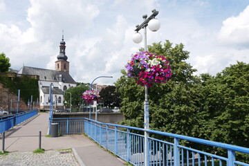 Fußgängerbrücke mit Blumenampel und Schlosskirche in Saarbrücken