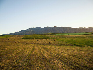 Fototapeta na wymiar field after harvest, mountains on the horizon, summer sunset