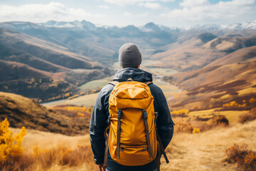 Hiker, tourist, person with yellow backpack. Autumn nature in mountains, panoramic landscape, traveler relax holiday concept, trip vacation, travel adventure. 