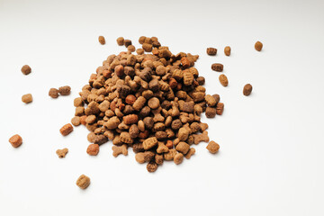 A slide of dry dog food on a white background. Heap of dry dog food on a white background.
