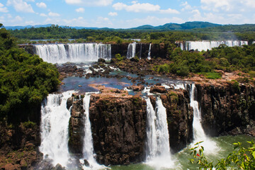 Panoramic view of Iguazu Falls with lush forest and dramatic sky 