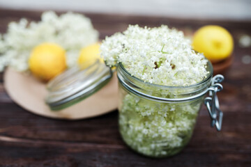 Grinding lemon and black elderberry on a cutting board to make an herbal drink or medicine for healing at home from syrup from elderberry flowers