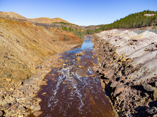 Aerial drone view of Tinto river in Huelva mountains. Red coloration has its origin in the weathering of minerals containing heavy metal sulfides found in deposits along the river and at its source