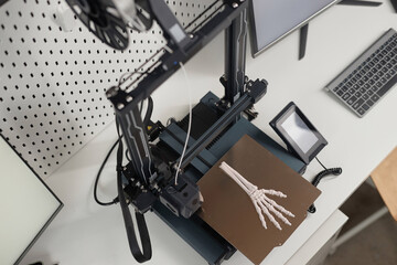Top down view of hand bone prototype on aluminum print bed of 3D printer on laboratory table