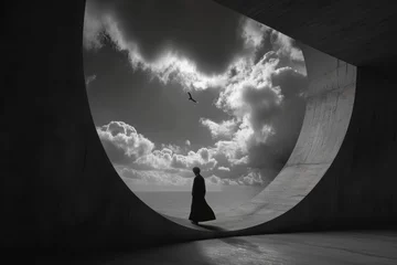 Fotobehang Conceptual image with a silhouette of a woman in a long black dress against the backdrop of the sky and clouds.  © Oskar Reschke