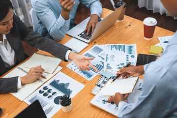 Multiracial analyst team use BI dashboard data to analyze financial report on meeting table. Group...