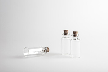 Three empty mini glas bottles with closed brown cork lid standing up. The rustic and vintage jar is small and clean. It looks like an old medicin keeping. 