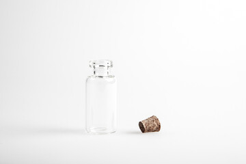 One empty mini glas bottles with open brown cork lid standing up. The rustic and vintage jar is small and clean. It looks like an old medicin keeping. 