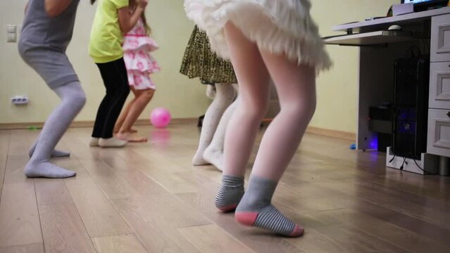 Five little girls in skirts and dress are dancing on the floor