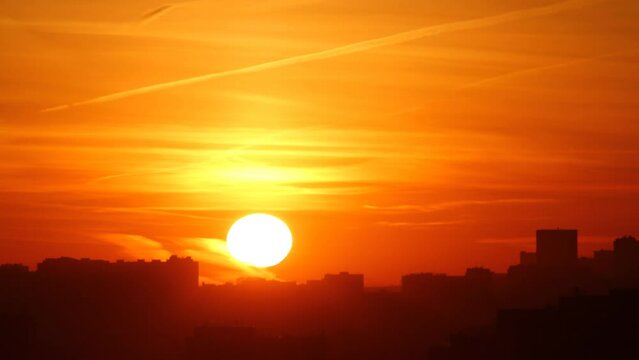 Silhouettes of houses of a modern city during sunrise. Time lapse.