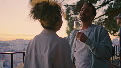 Flirting couple enjoying wine at sunset viewpoint closeup. Pair drinking alcohol