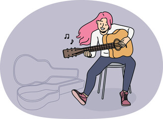 Overjoyed young woman with pink hair sit on chair playing guitar. Smiling millennial female artist or musician enjoy performance on musical instrument.