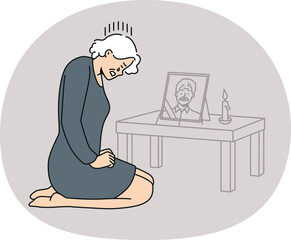 Desperate mature woman crying near husband portrait mourn after deceased spouse. Unhappy elderly grandmother grieve miss passed away grandfather.