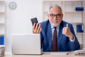 Old male employee working in the office