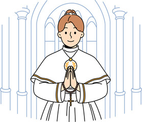 Little catholic girl takes part in first holy communion and stands in temple making prayer gesture
