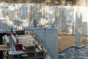 Building foundation construction. Monolithic concrete and reinforced concrete structures on the construction site. The use of metal formwork and fittings in construction.