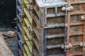 Building foundation construction. Monolithic concrete and reinforced concrete structures on the construction site. The use of metal formwork and fittings in construction.