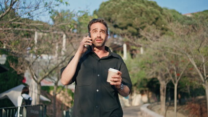 Hispanic tourist talking cell walking park closeup. Man holding coffee calling