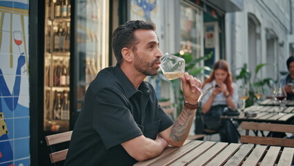Hispanic man sipping wine glass open air cafe bar closeup. Guy drinking alcohol