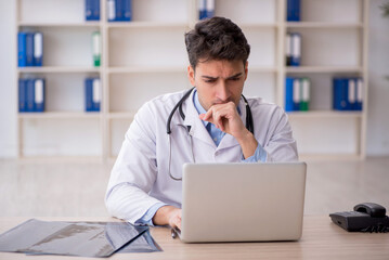 Fototapeta premium Young male doctor in telemedicine concept