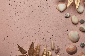 Chic summer beach theme with golden leaves on a pink surface with copy space