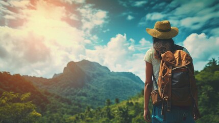 A fearless fashionista stands amidst the breathtaking mountain range, her stylish sun hat and rugged backpack a perfect contrast to the serene sky and billowing clouds
