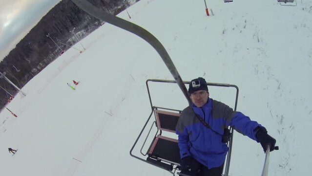 Man makes selfie on cableway in ski resort, top view