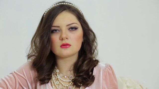 Young brunette smiles with necklace and diadem on head
