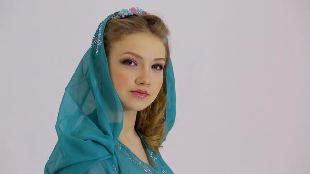 Young woman turns head and looks forward with hood on head