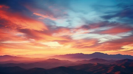  a sunset view of a mountain range with clouds in the sky and mountains in the foreground with a red and blue sky.