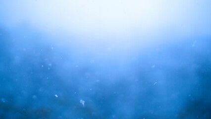 Blue snowfall background effect. Abstract dynamic energy background. Shallow depth of field with soft focus.